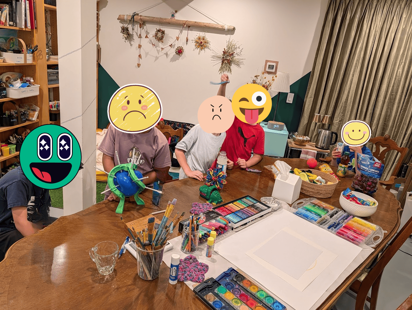Group art therapy at TATS. image of children at a therapy table playing games, having snacks, making art